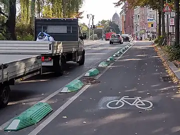 bump separation_kerb, lane_separator – small bumps/guide curbs/separation kerbs/armadillos mounted on the ground to make it more difficult for vehicles to pass over.