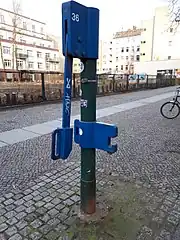 Andere Lackierungen als das verbreitete Chromoxidgrün sind verbreitet, so eine grüne Säule mit blau lackiertem Wasserauslauf und Handschwengel...