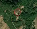 6/8 Communication tower (man_made=tower and tower:type=communication), with an antenna and a small building, on top of a plain (Maxar satellite imagery).