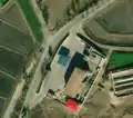 3/3 Gas station (amenity=fuel) located south of Kowon, along the main road, with a shadow cast revealing the structure with posts (Bing satellite imagery).