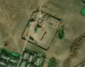 1/6 Farmyard (landuse=farmyard) surrounded by a fence dotted with hay stacks, crossed by a road (Maxar satellite imagery).