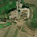 6/6 Farmyard (landuse=farmyard) composed of long buildings dotted with hay stacks. Disordered cemetery in lower right of image (see section on cemeteries for more detail) (Maxar satellite imagery).