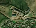 3/6 Farmyard (landuse=farmyard) surrounded by a fence dotted with hay stacks, close to a road very close to a village (Maxar satellite imagery).