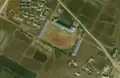 4/4 Even rarer form of school (amenity=school) consisting of three long buildings (building=school) and a large schoolyard in front (Maxar satellite imagery).