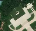 4/4 The same statues of Kim Il-sung and Kim Jong-Il (tourism=artwork and artwork_type=statue) on a white square plinth with satellite imagery (satellite imagery Maxar).