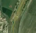 6/6 Small dam (waterway=weir) that cuts off a stream leaving a smaller flow and bed to the south (Maxar satellite imagery).