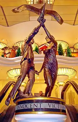 Bronze statue showing Diana and Dodi facing each other in flowing clothing beneath the outstretched wings of an albatross