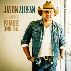 An image of Aldean wearing a white shirt, denim jeans and jacket, and cowboy hat while both hands are in his pockets.