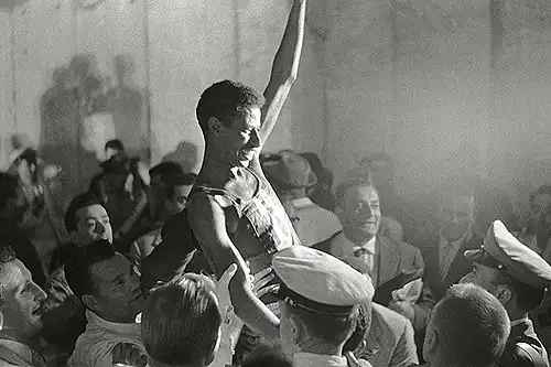 Abebe lifted above a crowd in celebration