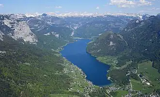 A body of water flowing through a valley, surrounded by highlands and mountain ranges.