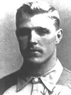 A black and white photograph of a man in a buttoned top