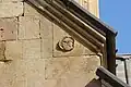 High-relief decoration of a face upon the upper portion of the western façade.