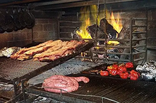 Table with a cut of Argentine beef, wine, sauces and spices