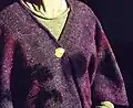The disc being worn showing possible means of attachment to tunic or other garment.