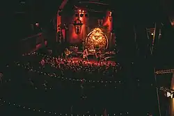 A thin, ornate room packed with fans