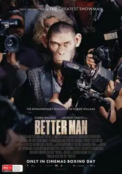 An anthropomorphic chimpanzee wearing a suit is surrounded by paparazzi.