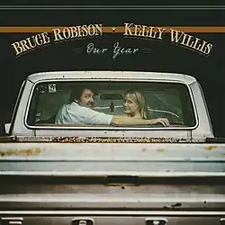 A photograph of Robison and Willis seated in a pickup truck, looking at the camera in the rear