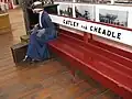 Model of woman sitting on a station bench where visitors can also sit
