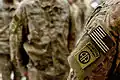 A paratrooper assigned to the 82nd Airborne Division displays his newly-awarded shoulder sleeve insignia-former wartime service patch during a ceremony in Baghdad, Iraq, July 4, 2015