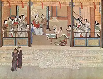 A building with many richly dressed women inside in the background with two men standing