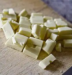 Creamy colored, regularly broken pieces of a block haphazardly piled on a table