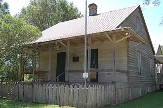 A raised wooden cottage with a large front porch.
