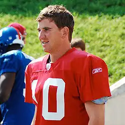 An American football player wearing a red jersey with a white number "10".