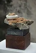 Presenting the Stone V (20x20x30 cm), glazed earthenware, porcelain, fossil limestone, coral stone and steel, 2004