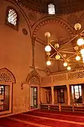 The prayer hall of the mosque, with the women's upper gallery, and a view of Islamic frescos along the arches and squinches