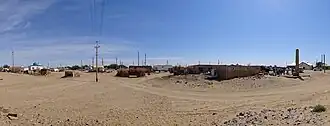 A panorama from the entrance to the village of Erbent (Yerbent). On the right side of the photo a group of tourists standing next to the Basmachi Revolt monument can be seen.