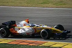 a brightly coloured F1 car drives on a track