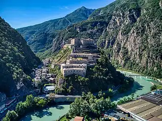 Photo shows a narrow valley and houses dominated by Fort Bard.