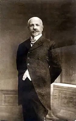 Photograph of Francesc Ferrer, standing, wearing a suit and a beard
