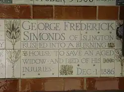A tablet formed of five tiles of varying sizes, bordered by yellow and blue flowers in an art nouveau style
