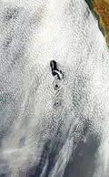 Glory captured from space. The elongated shape is an artifact of the composite stitching of the photo, not its real shape.