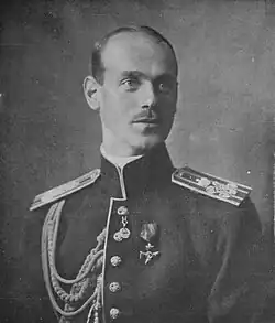 White male with classically-handsome features and a thin moustache wearing military uniform
