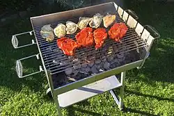 A brazier being used to grill chicken and steaks