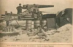 soldier standing in front of a large gun