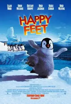 One smiling penguin dances while other penguins stand in the background