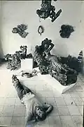 Tejada posing with several wooden sculptures, 1963