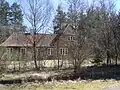 Brick house with overgrown shrubs blocking its view