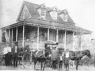 Horses and wagons in front of the house