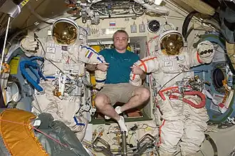 Maksim Surayev next to two Orlan-MK spacsuits in Poisk.