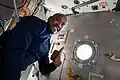 A smiling Glover poses next to a hatch in Node 1.