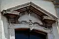 Open pediment of the central window on the upper level.