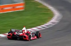 Photograph of Wilson in a Dallara DW12 Honda racing into a curve