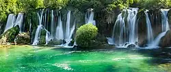 A scene when the sun broke through lighting up the Kravica Waterfalls