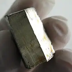 A block of metal in a gloved hand