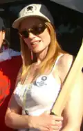 Woman in white knit blouse with hat, sunglasses and red hair