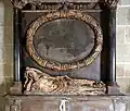 Detail of the monument to Cecily Walmstrey (d.1649), Worcester Cathedral. The wreathed oval medallion once held a painted inscription. She is shown as a strangely animated corpse in a winding sheet.